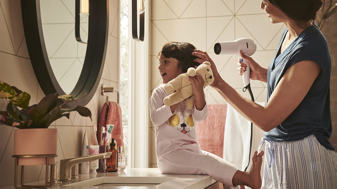 Girl on Sink with Adult Blowdrying Hair and American Standard Faucet