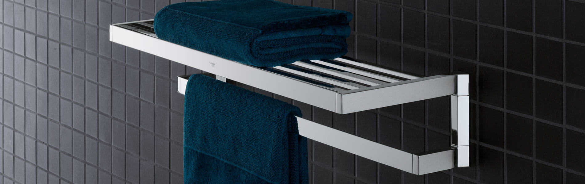 Selection cube towel rack on a black tiled wall.