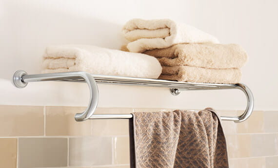 Essentials Authentic accessory towel rack with folded towels on top of it.