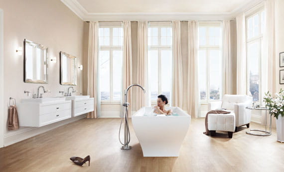 Women taking a bath next to a standing Grandera faucet.