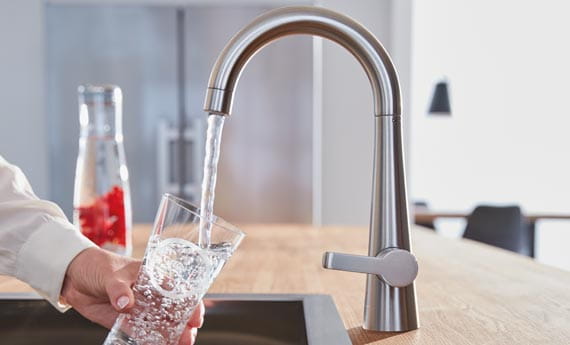 GROHE Zedra Kitchen Faucet by GROHE filling up a glass with water